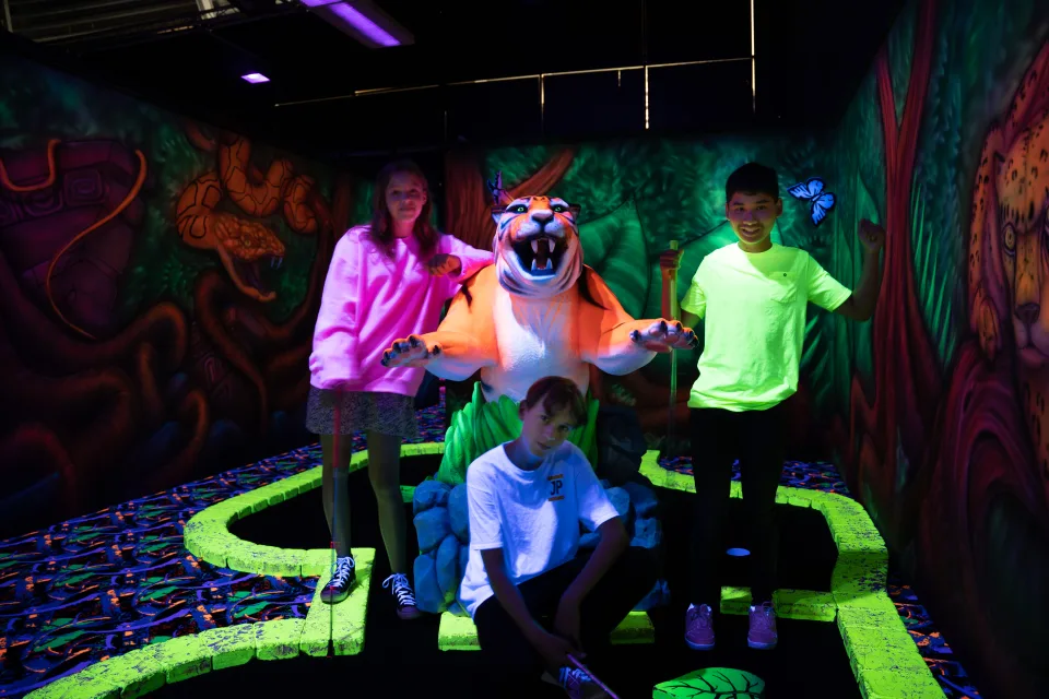 Kinderen bij de neon minigolfbaan van PlazaSportz Assen
