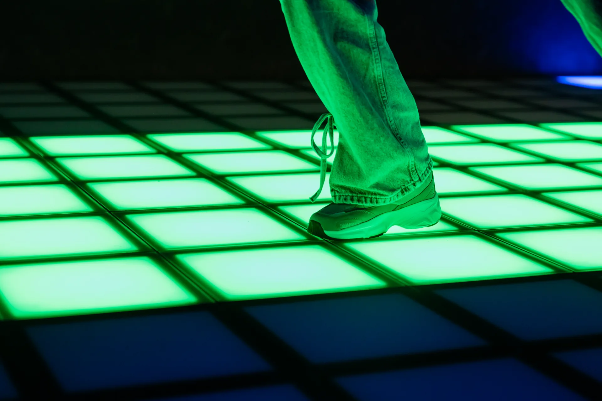 Close-up van een schoen op de groene LED-tegels van de Pixel Floor