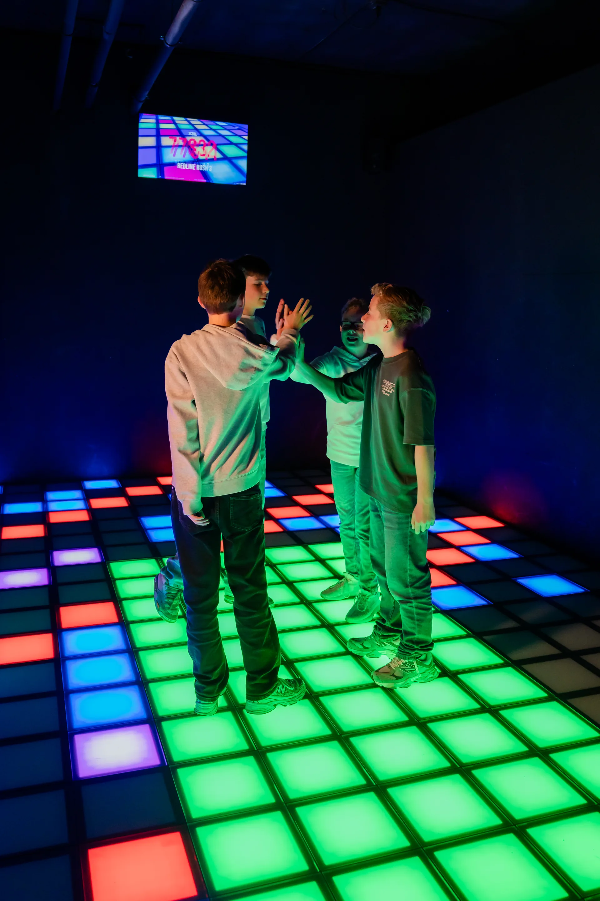 Vrienden high-fiven na een game op de Pixel Floor bij Pixel Play Rotterdam